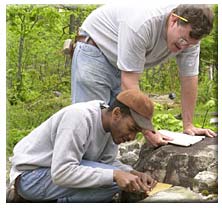 Professor and Graduate Student analyzing rock formation.